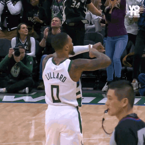 a basketball player with the name lillard on his jersey stands on the court