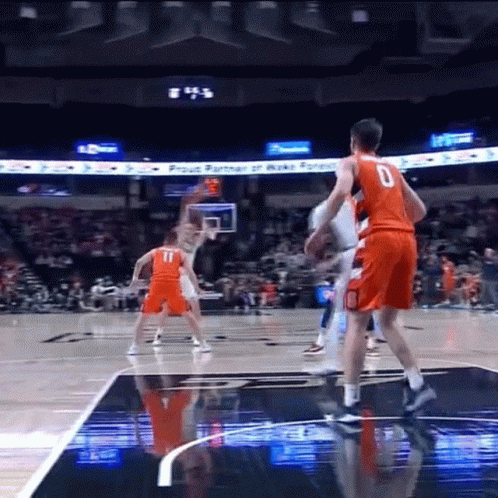 a basketball player with the number 0 on his jersey stands on the court