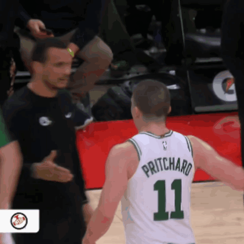 A Basketball Player With The Number 11 On His Jersey Talks To Another Player GIF