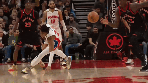 A Basketball Player With The Number 12 On His Jersey Is Being Fouled GIF