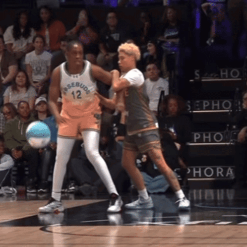 A Basketball Player With The Number 12 On His Jersey Is Playing Against Another Player GIF