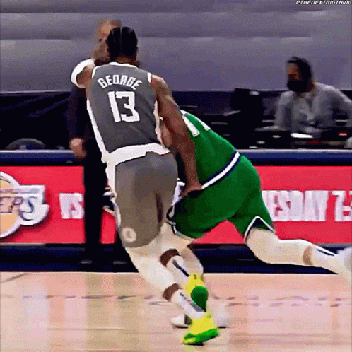 a basketball player with the number 13 on his jersey is fighting another player