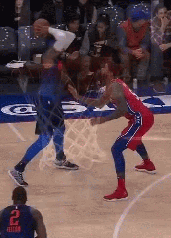 A Basketball Player With The Number 2 On His Jersey Is Trying To Block Another Player 'S Shot . GIF