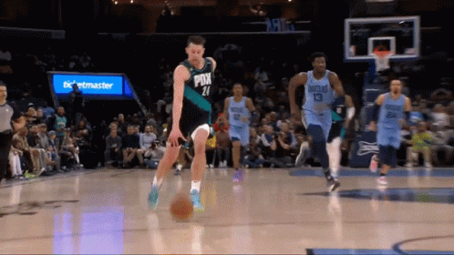 A Basketball Player With The Number 21 On His Jersey Dribbles The Ball GIF