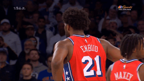 A Basketball Player With The Number 21 On His Jersey Stands In Front Of A Crowd GIF