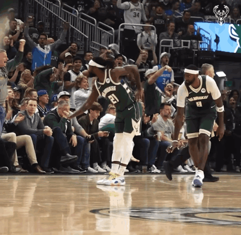 A Basketball Player With The Number 21 On His Jersey Stands On The Court GIF