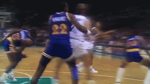 A Basketball Player With The Number 22 On His Jersey Is Being Fouled By Another Player GIF