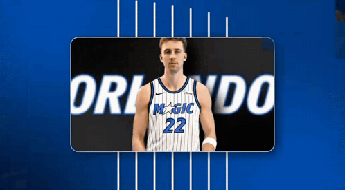 A Basketball Player With The Number 22 On His Jersey Stands In Front Of A Blue Background GIF