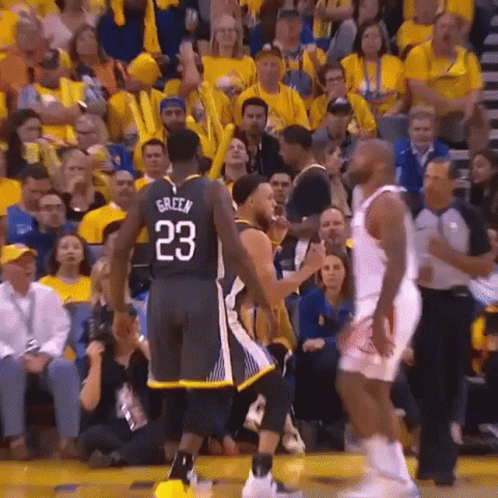 A Basketball Player With The Number 23 On His Jersey Is Talking To Another Player On The Court . GIF