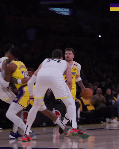 A Basketball Player With The Number 24 On His Back Dribbles The Ball GIF