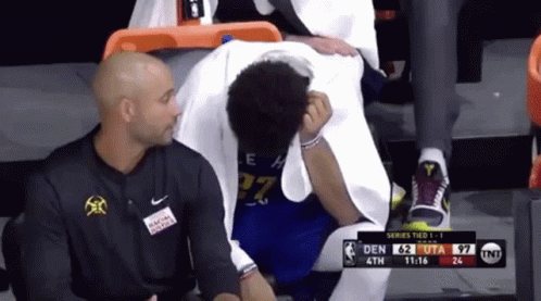 A Basketball Player With The Number 27 On His Jersey Is Sitting On The Bench GIF