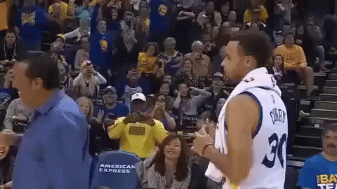 A Basketball Player With The Number 30 On His Jersey Is Standing In Front Of A Crowd Of People . GIF