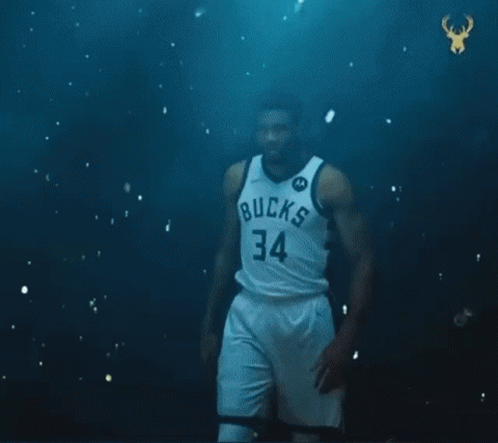 A Basketball Player With The Number 34 On His Jersey Is Standing In Front Of A Green Ball . GIF