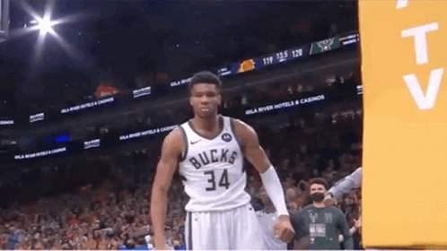 A Basketball Player With The Number 34 On His Jersey Stands In Front Of A Crowd . GIF