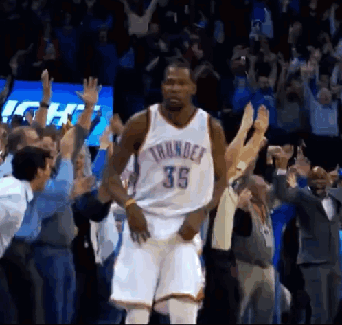 A Basketball Player With The Number 35 On His Jersey Is Standing In Front Of A Crowd Of People . GIF