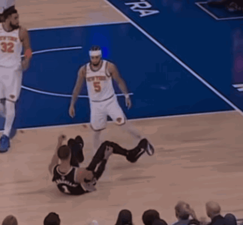 A Basketball Player With The Number 5 On His Jersey Is Sitting On The Floor GIF