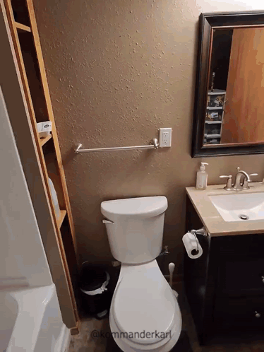 A Bathroom With A Toilet A Sink And A Mirror With The Words " Kommanderkarl " On The Bottom GIF