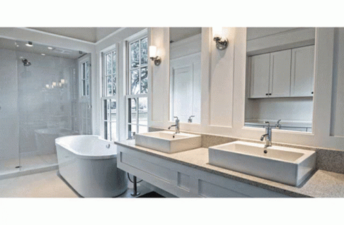 A Bathroom With Two Sinks And A Bathtub And Two Mirrors GIF