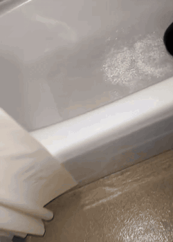 A Bathtub With A Lot Of Foam On The Floor GIF