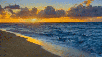 A Beach With A Sunset In The Background And Waves Crashing On The Sand GIF