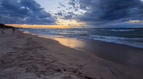 A Beach With A Sunset In The Background GIF