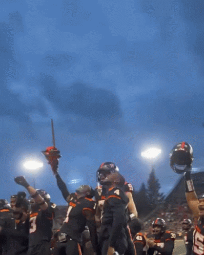 a beaver football player holds up a chainsaw in his hands