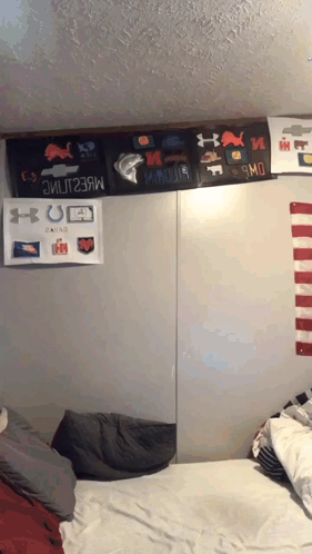 A Bed In A Dorm Room With A Bunch Of Stickers On The Wall GIF