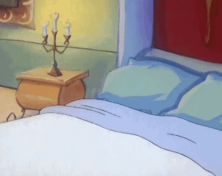 A Bed With Blue Sheets And A Nightstand With Candles GIF