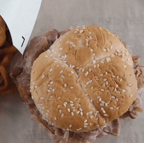 A Beef Sandwich With Sesame Seeds On A Bun GIF