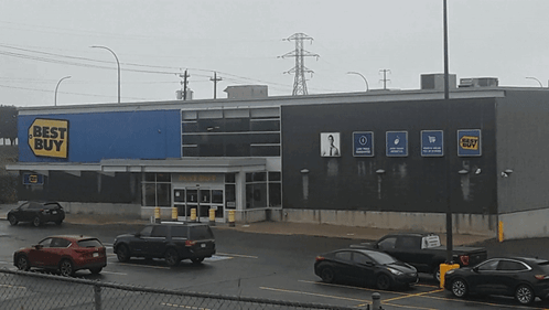 A Best Buy Store With Cars Parked In Front GIF