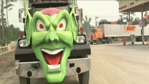 A Bic Truck Is Parked Next To A Truck With A Green Face On It GIF
