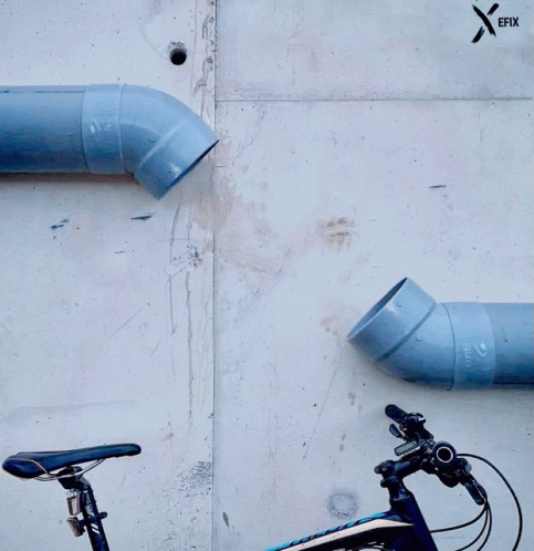 A Bicycle Is Parked Next To A Wall With Pipes And A Sticker That Says Efix GIF