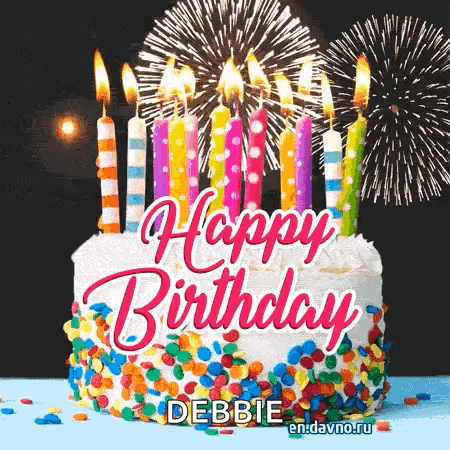 A Birthday Cake With Candles And Fireworks Behind It GIF