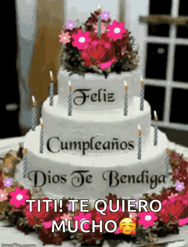 A Birthday Cake With Candles And Flowers On Top Of It GIF