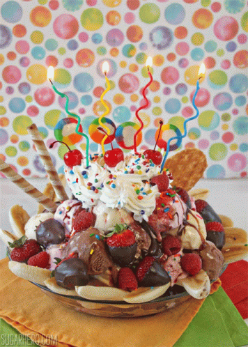 A Birthday Ice Cream Sundae With Candles In It GIF