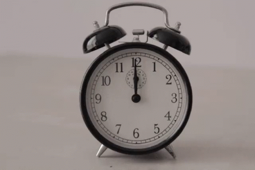 A Black And White Alarm Clock Shows That It Is Almost 5:00 GIF