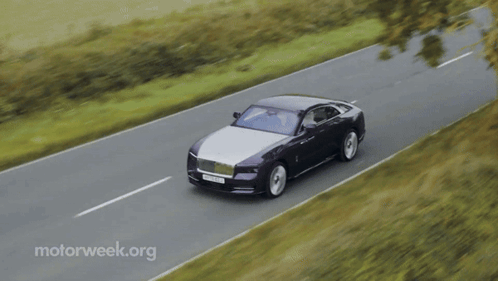 A Black And White Car Is Driving Down A Road With Motorweek.org In The Corner GIF