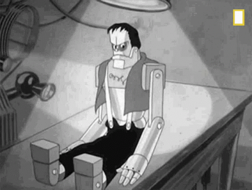 A Black And White Cartoon Of Frankenstein Sitting On Top Of A Table . GIF
