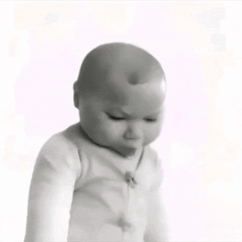a black and white photo of a baby looking down