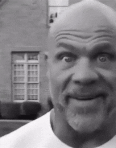 a black and white photo of a bald man with a beard making a funny face
