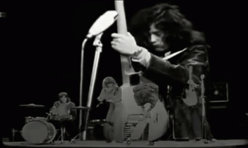 A Black And White Photo Of A Band Playing Instruments On A Stage GIF