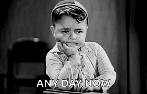 A Black And White Photo Of A Boy Sitting At A Desk With His Hand On His Chin And The Words `` Any Day Now '' . GIF