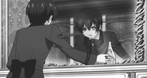 a black and white photo of a boy standing in front of a mirror .