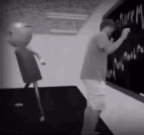 A Black And White Photo Of A Boy Writing On A Chalkboard .. GIF