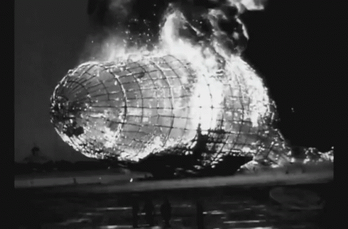 A Black And White Photo Of A Burning Airship With Flames Coming Out Of It GIF