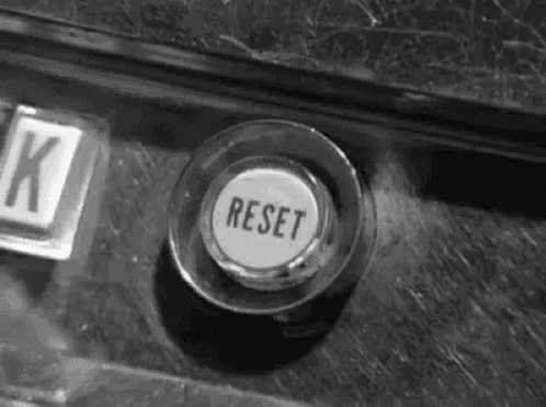 A Black And White Photo Of A Button That Says Reset On It . GIF