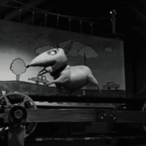A Black And White Photo Of A Cartoon Dog On A Cart GIF