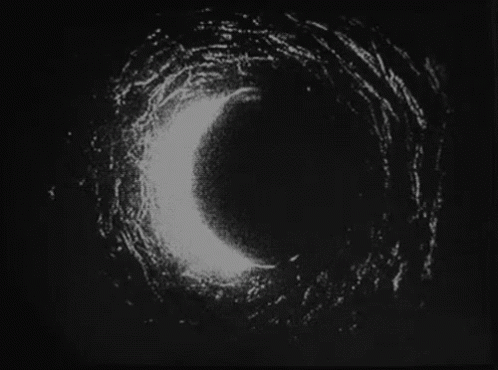 A Black And White Photo Of A Circle In The Dark . GIF