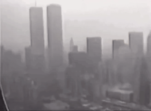 A Black And White Photo Of A City Skyline With A Few Buildings In The Distance . GIF