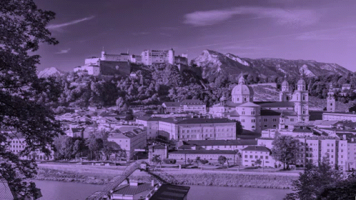 A Black And White Photo Of A City With A Castle On Top Of A Hill GIF